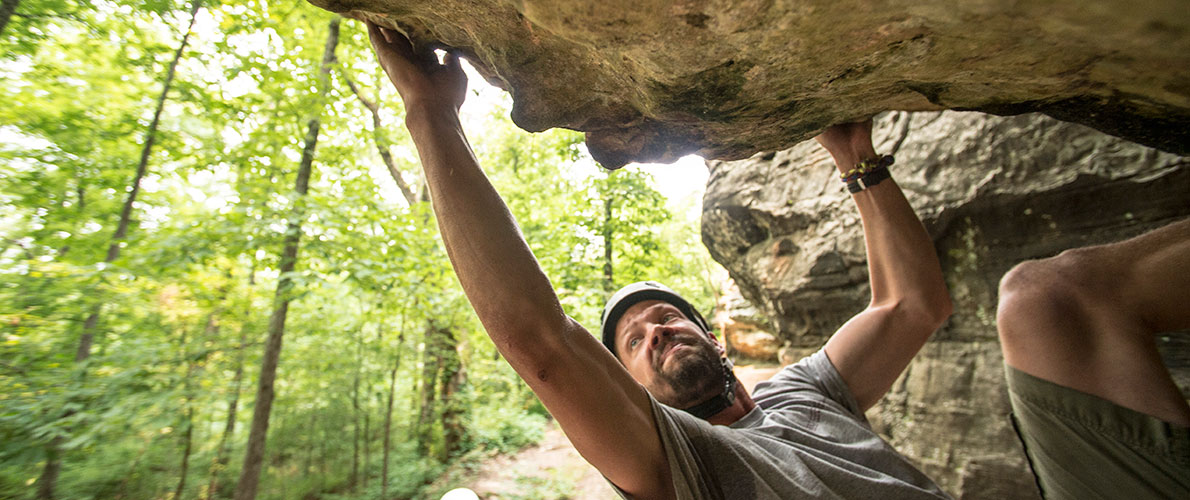 man scaling a rockface